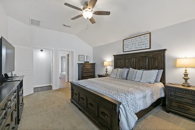 a spacious bedroom with a bed and a chandelier