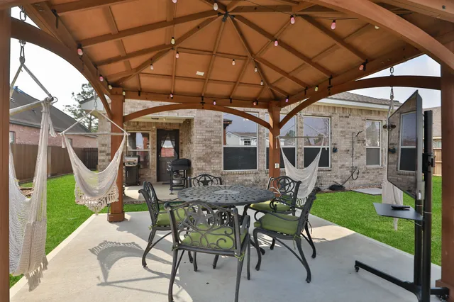 a view of yard with table and chairs under an umbrella