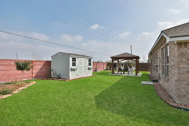 a aerial view of a house next to a yard and large tree