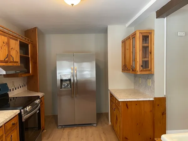 a kitchen with stainless steel appliances granite countertop a refrigerator and a stove