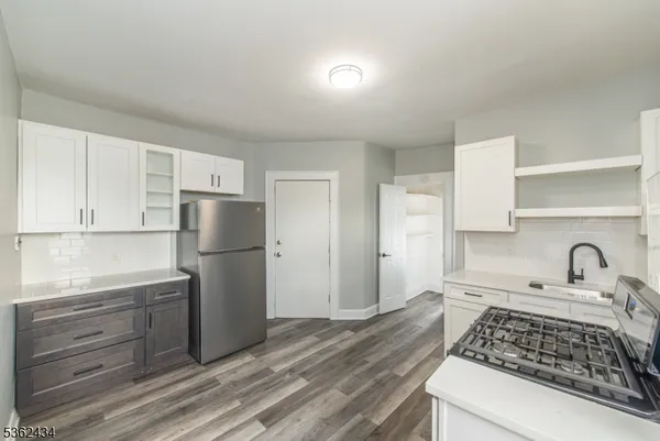 a kitchen with a refrigerator and a stove top oven