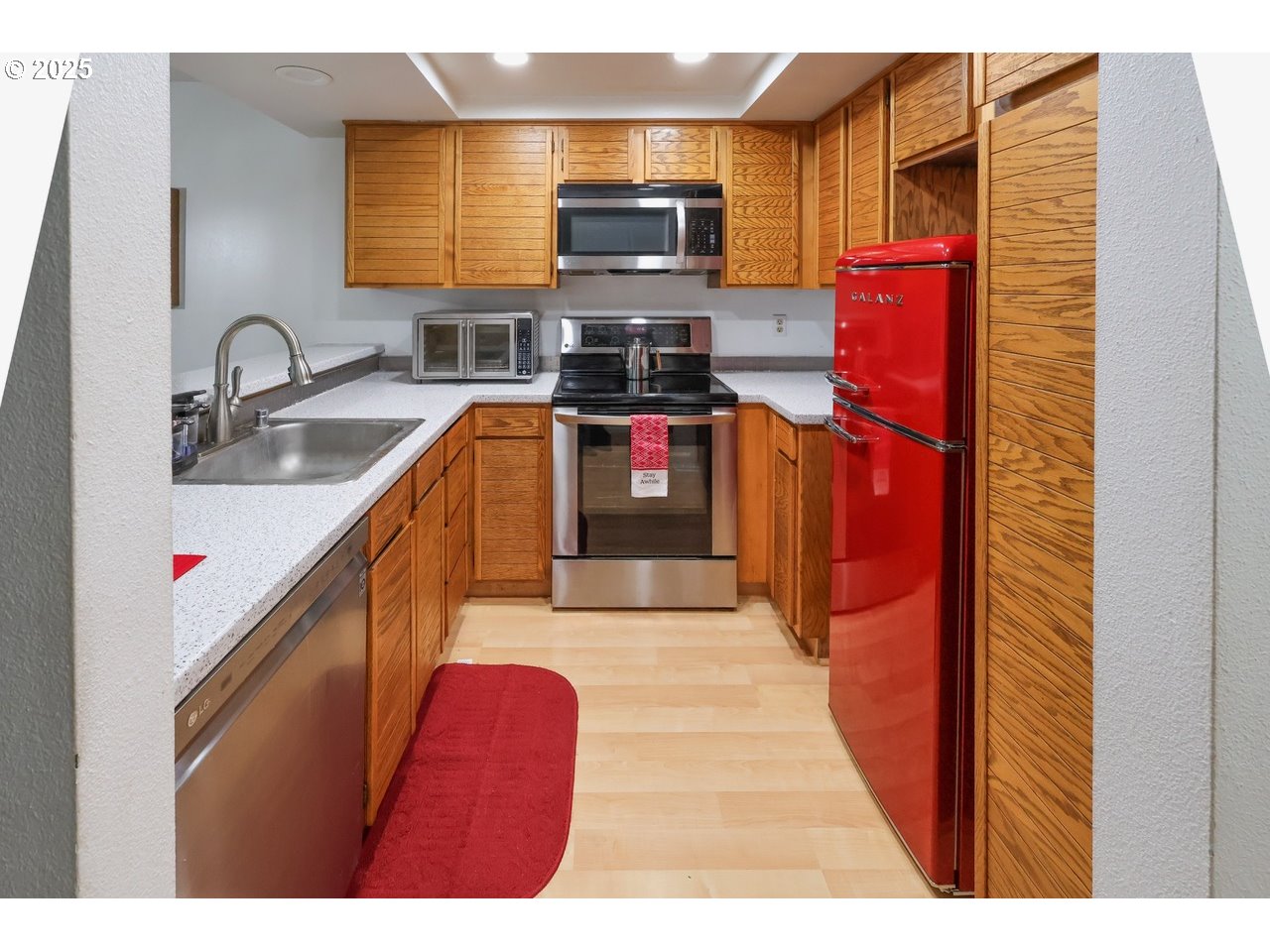 7824 Northeast Loowit Loop, Unit 70 Vancouver, WA 98662 - Photo 6 of 26 a kitchen with stainless steel appliances kitchen island granite countertop a stove a sink and a microwave