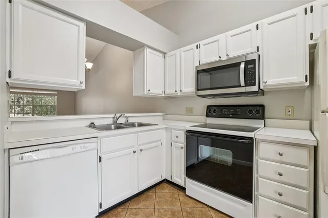 a kitchen with white cabinets stainless steel appliances and sink