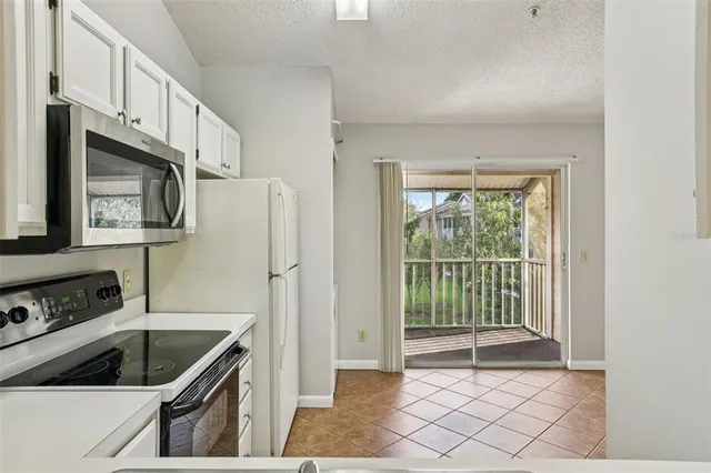 a kitchen with granite countertop a refrigerator and a sink