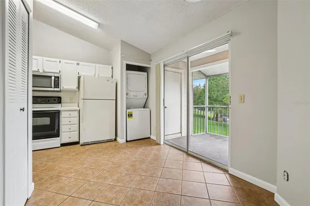 a view of a kitchen with refrigerator and more cabinets