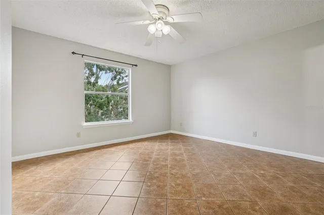 an empty room with a ceiling fan and a window
