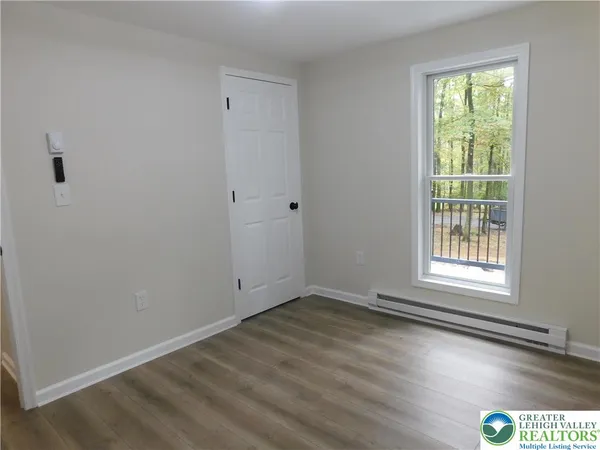 a view of an empty room with wooden floor