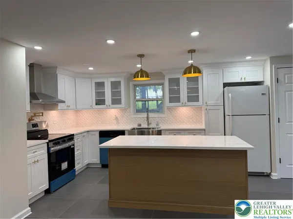 a kitchen with stainless steel appliances granite countertop a sink and a refrigerator