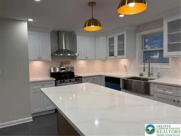a kitchen with kitchen island a counter space a stove and a sink
