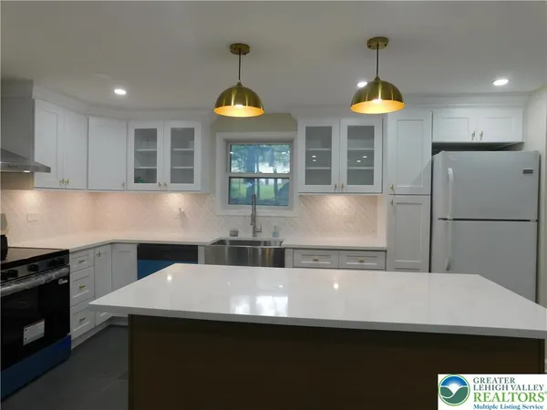 a kitchen with stainless steel appliances a sink a stove a refrigerator and cabinets