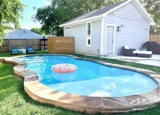 a view of a house with backyard and sitting area