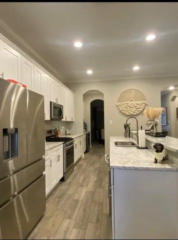 a kitchen with stainless steel appliances granite countertop a sink a stove and a refrigerator