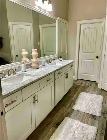 a spacious bathroom with a granite countertop double vanity sink and a mirror