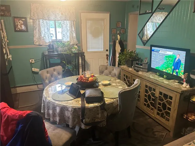 a dining room with furniture and a flat screen tv