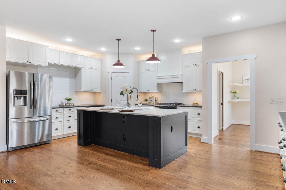 1616 Bowling Road Fuquay-Varina, NC 27526 - Photo 6 of 33 a kitchen with stainless steel appliances granite countertop a refrigerator a sink dishwasher a stove and white cabinets with wooden floor