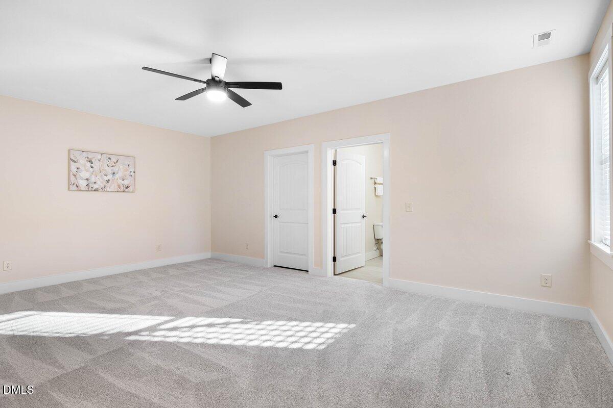 1616 Bowling Road Fuquay-Varina, NC 27526 - Photo 24 of 33 a view of a livingroom with a ceiling fan & kitchen space