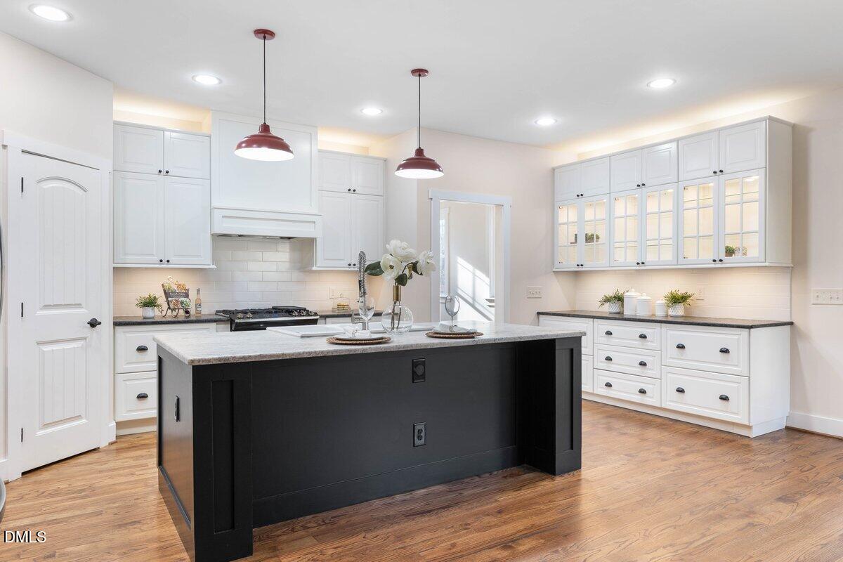 1616 Bowling Road Fuquay-Varina, NC 27526 - Photo 5 of 33 a kitchen with kitchen island granite countertop a sink a stove and cabinets