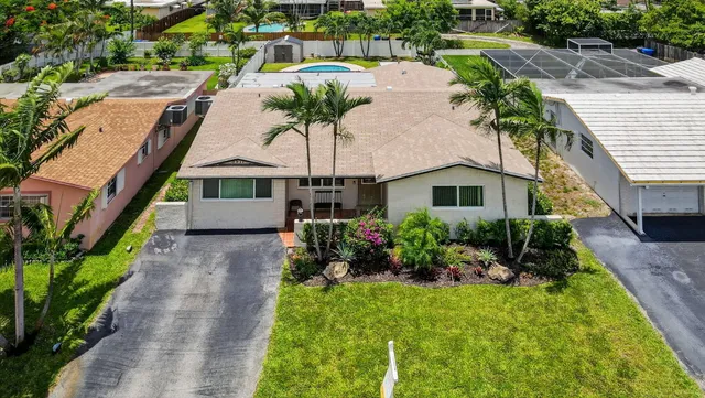 an aerial view of residential houses with outdoor space and parking