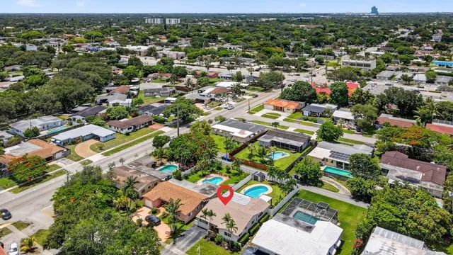 an aerial view of a house with large trees and a park