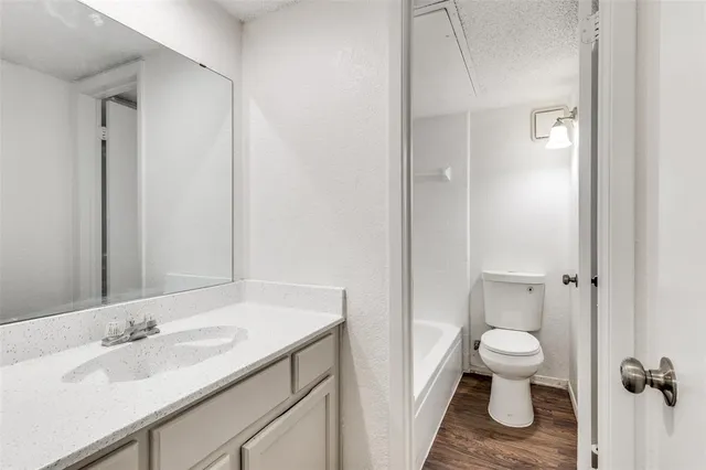 a bathroom with a granite countertop sink toilet and shower curtains