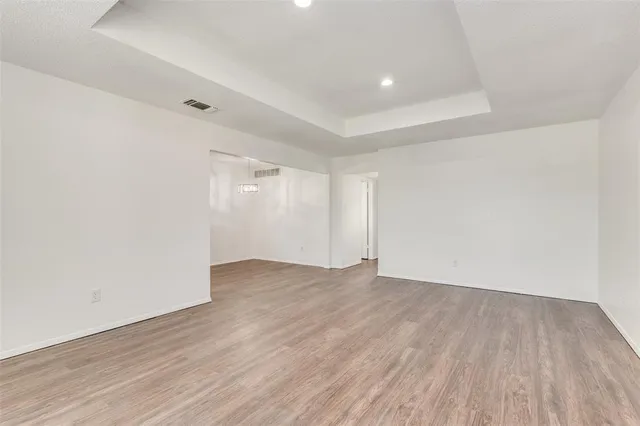 a view of an empty room with wooden floor