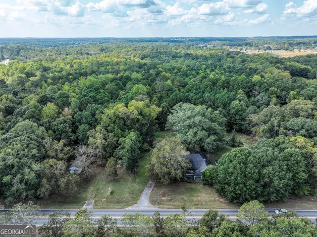 an aerial view of residential houses with outdoor space and trees