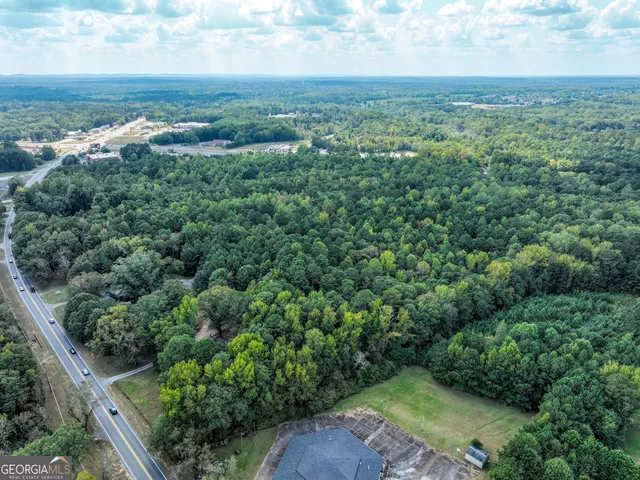 an aerial view of residential houses with outdoor space and trees