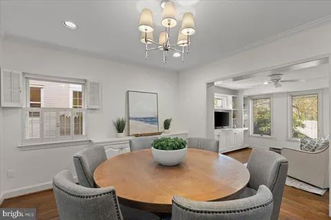 a dining room with furniture potted plants and wooden floor