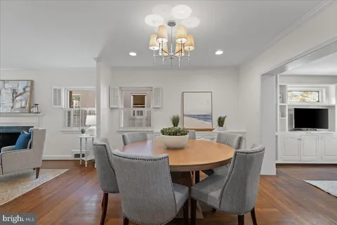a dining room with furniture a livingroom view and wooden floor