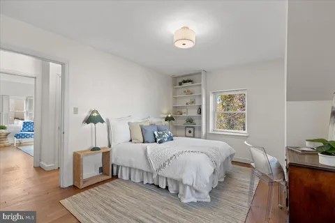 a bedroom with a large bed and a potted plant