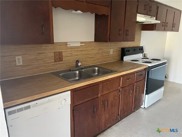 a kitchen with stainless steel appliances granite countertop a sink stove and cabinets