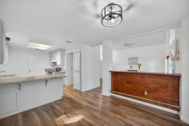 a view of a kitchen with cabinets and wooden floor