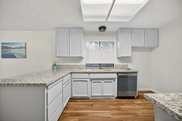 a kitchen with stainless steel appliances granite countertop a sink stove and cabinets