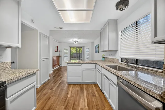 a large kitchen with granite countertop a sink stove refrigerator dining table and chairs