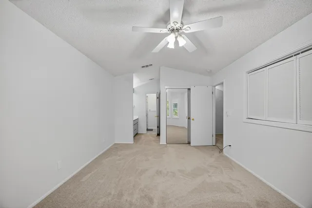 a view of a livingroom with a chandelier fan and entryway