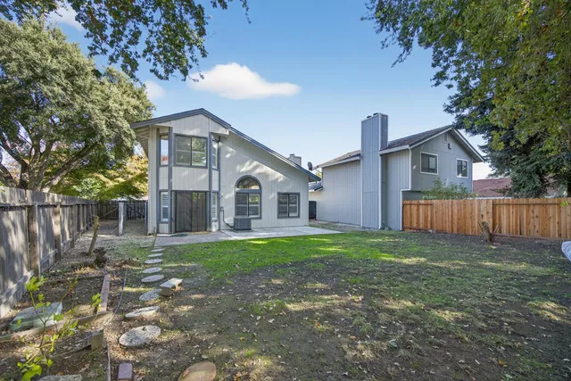 a front view of a house with a yard and trees