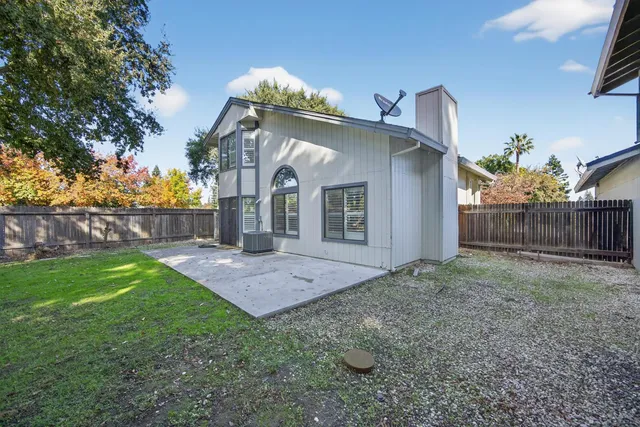 a backyard of a house with plants and wooden fence