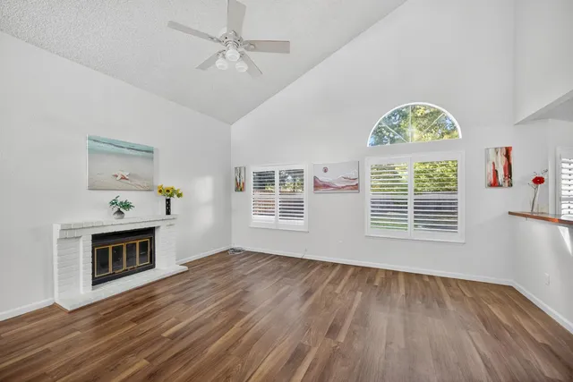 a view of an empty room with a window and fireplace