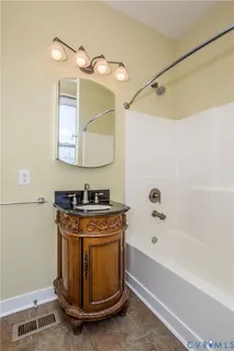 a bathroom with a granite countertop sink a mirror and a bathtub