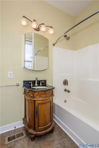 a bathroom with a granite countertop sink a mirror and a bathtub