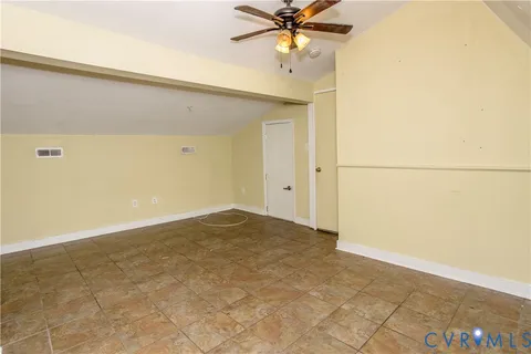 an empty room with a ceiling fan and carpet
