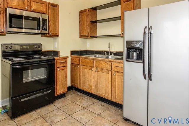 a kitchen with stainless steel appliances granite countertop a refrigerator stove and sink