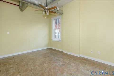 an empty room with windows and fan