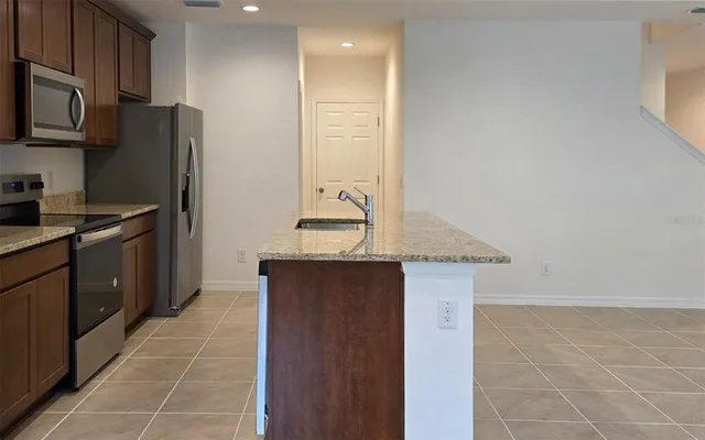 a kitchen with stainless steel appliances granite countertop a sink and a refrigerator