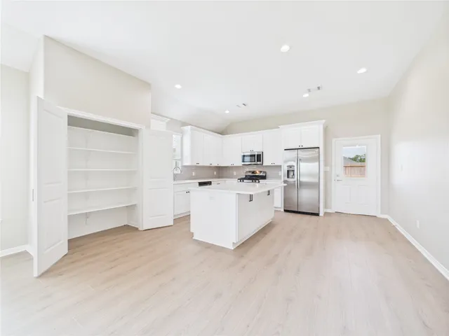 a view of empty room with cabinet and ceiling fan