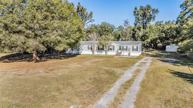 a front view of a house with a yard and trees