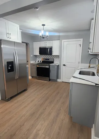 a kitchen with stainless steel appliances a refrigerator stove and microwave