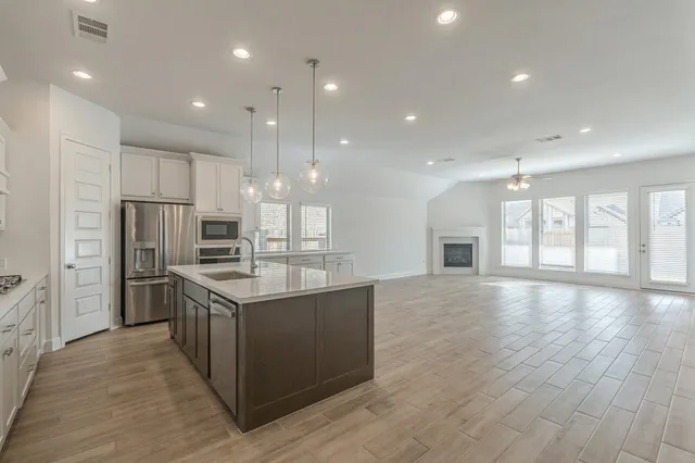 a kitchen with stainless steel appliances granite countertop a stove and a refrigerator