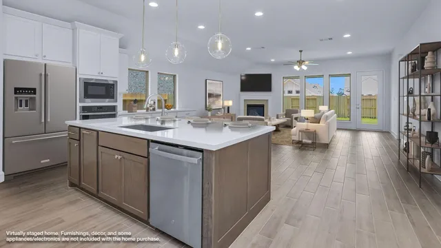 a kitchen with stainless steel appliances granite countertop a sink dishwasher a stove and a refrigerator with wooden floor