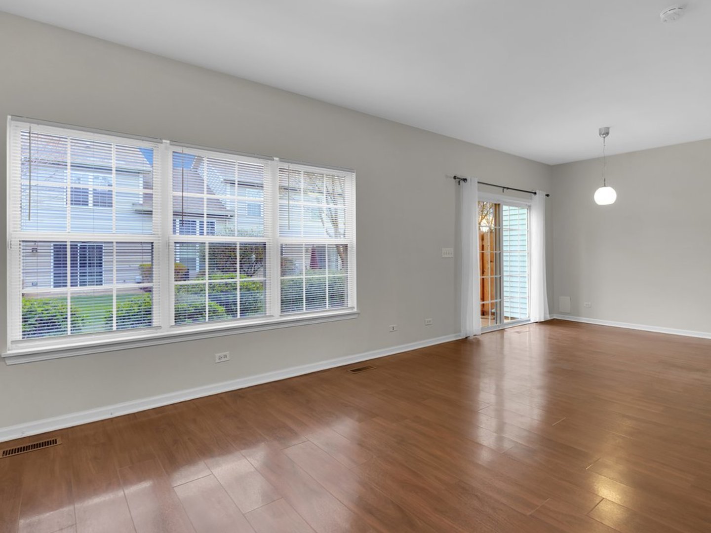 10089 Thornton Way Huntley, IL 60142 - Photo 4 of 16 a view of an empty room with a window and wooden floor